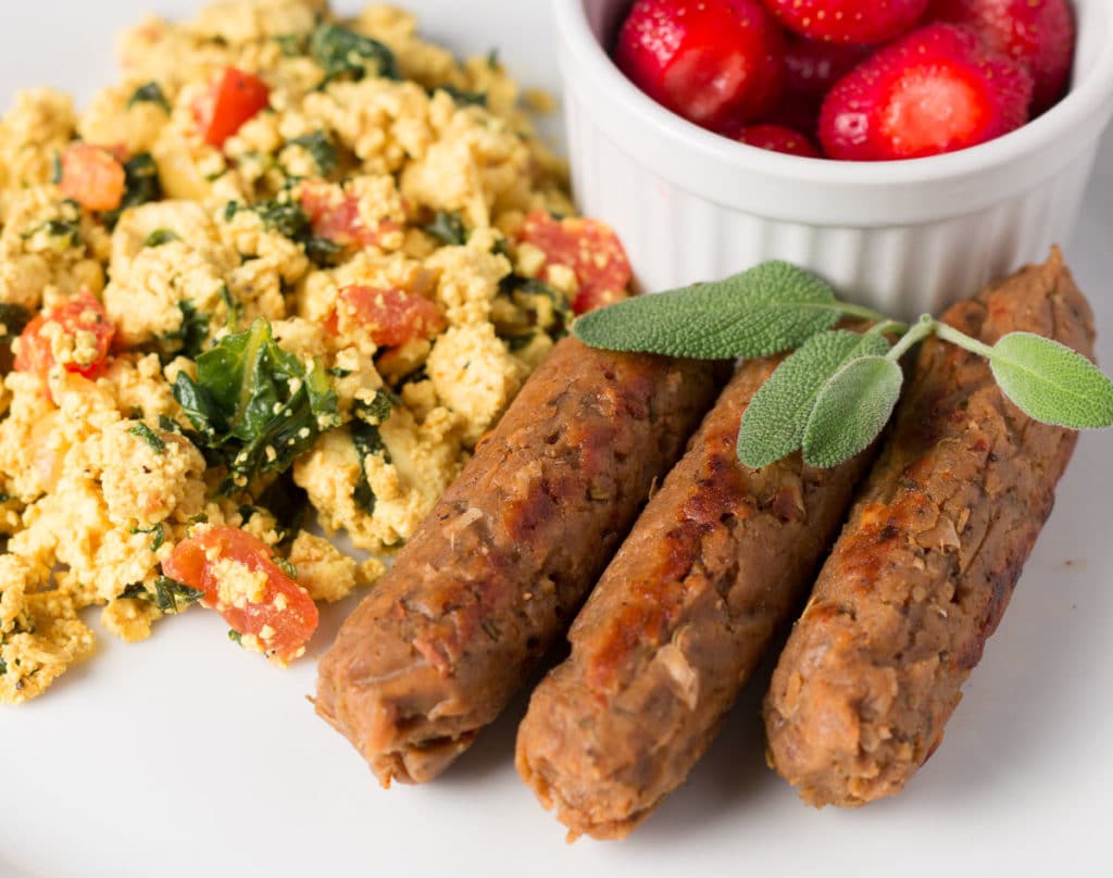 Breakfast Sausage Links with tofu scramble and bowl of strawberries