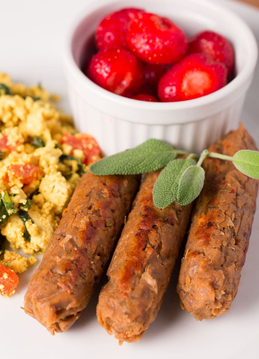 Breakfast Sausage Links with tofu scramble and bowl of strawberries