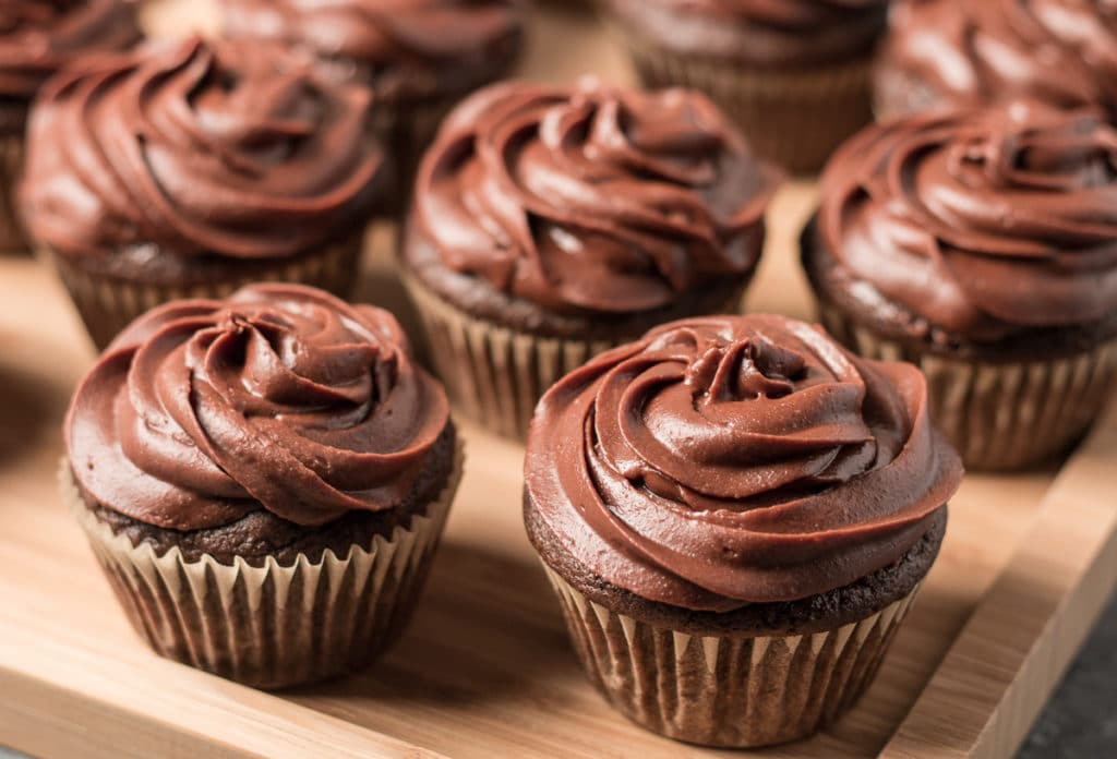 Chocolate cupcakes on a wooden tray.