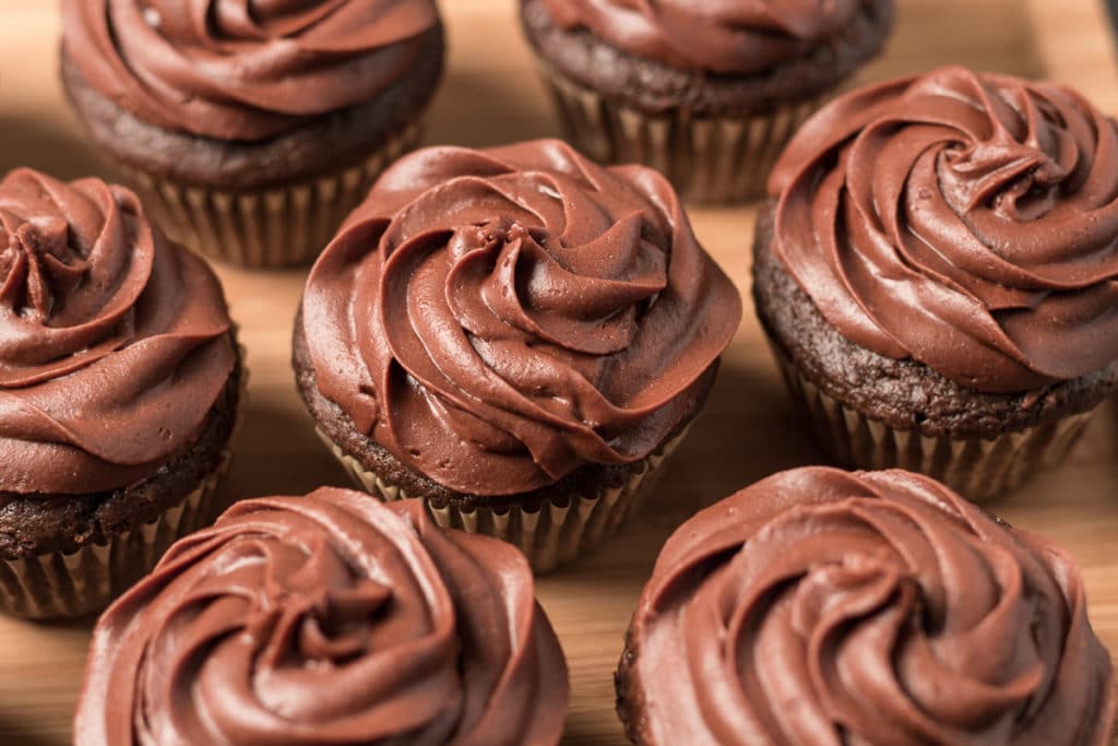 Picture of seven chocolate cupcakes on wooden tray