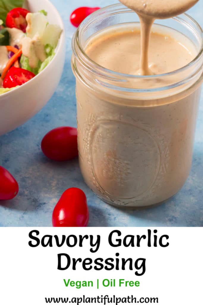 Jar of Savory Garlic Dressing and bowl of salad
