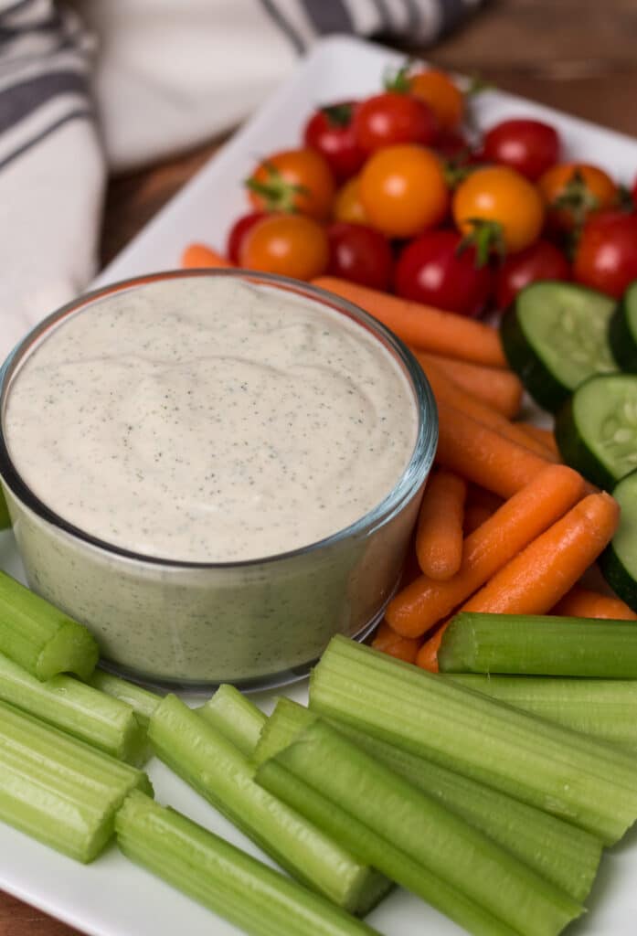 Veggie tray with bowl of dressing, and cloth napkin beside it