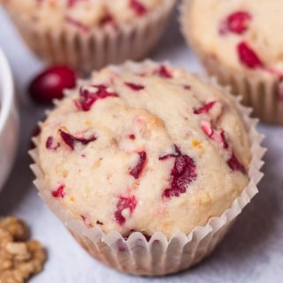 CLoseup of muffin next to a bowl of cranberries