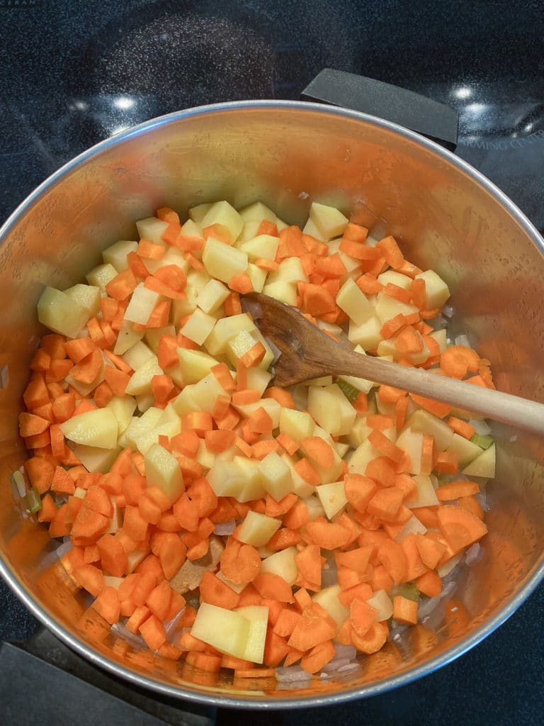 Carrots and potatoes added to pot