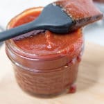 Jar of sauce with basting brush resting on top of jar