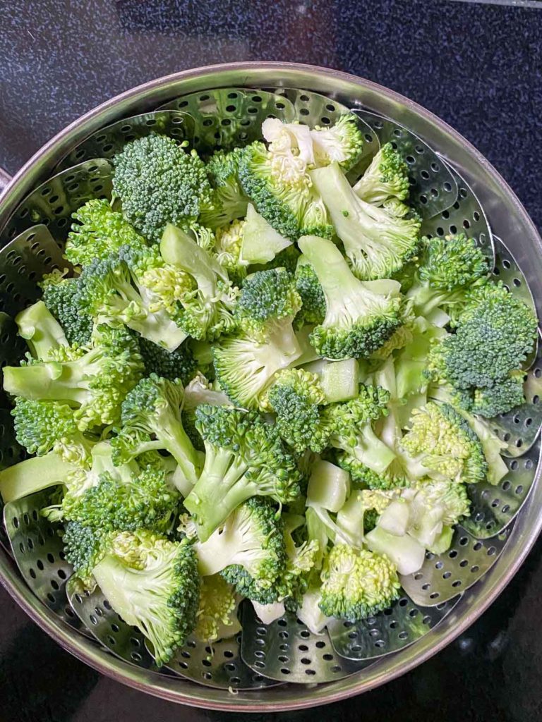 Broccoli in steamer basket inside a pot