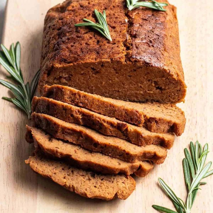 Partially sliced Seitan roast beef garnshed with rosemary