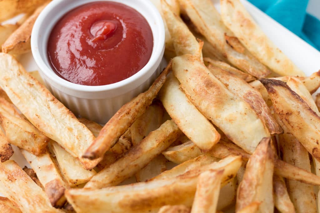 Baked french fries with cup of ketchup