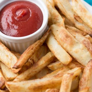 Baked french fries with cup of ketchup