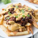 Vegan chili cheese fries on a white plate