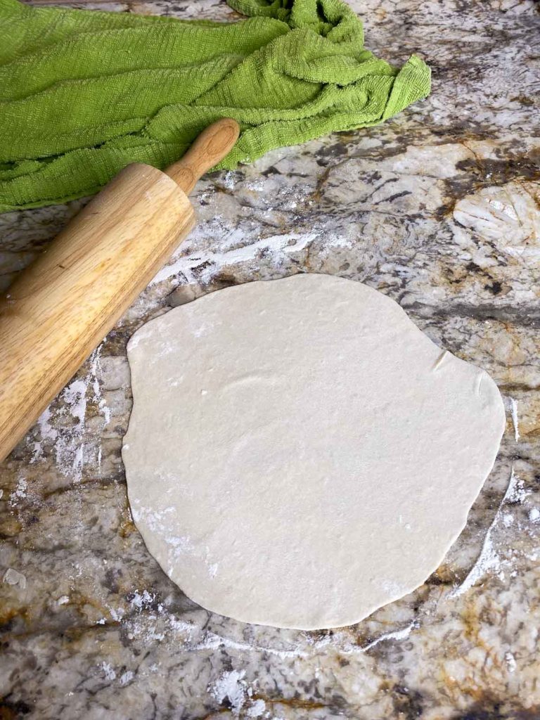 Tortilla dough rolled out and ready to be cooked