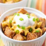 Small bowl of cheesy fiesta potatoes with another bowl in background.