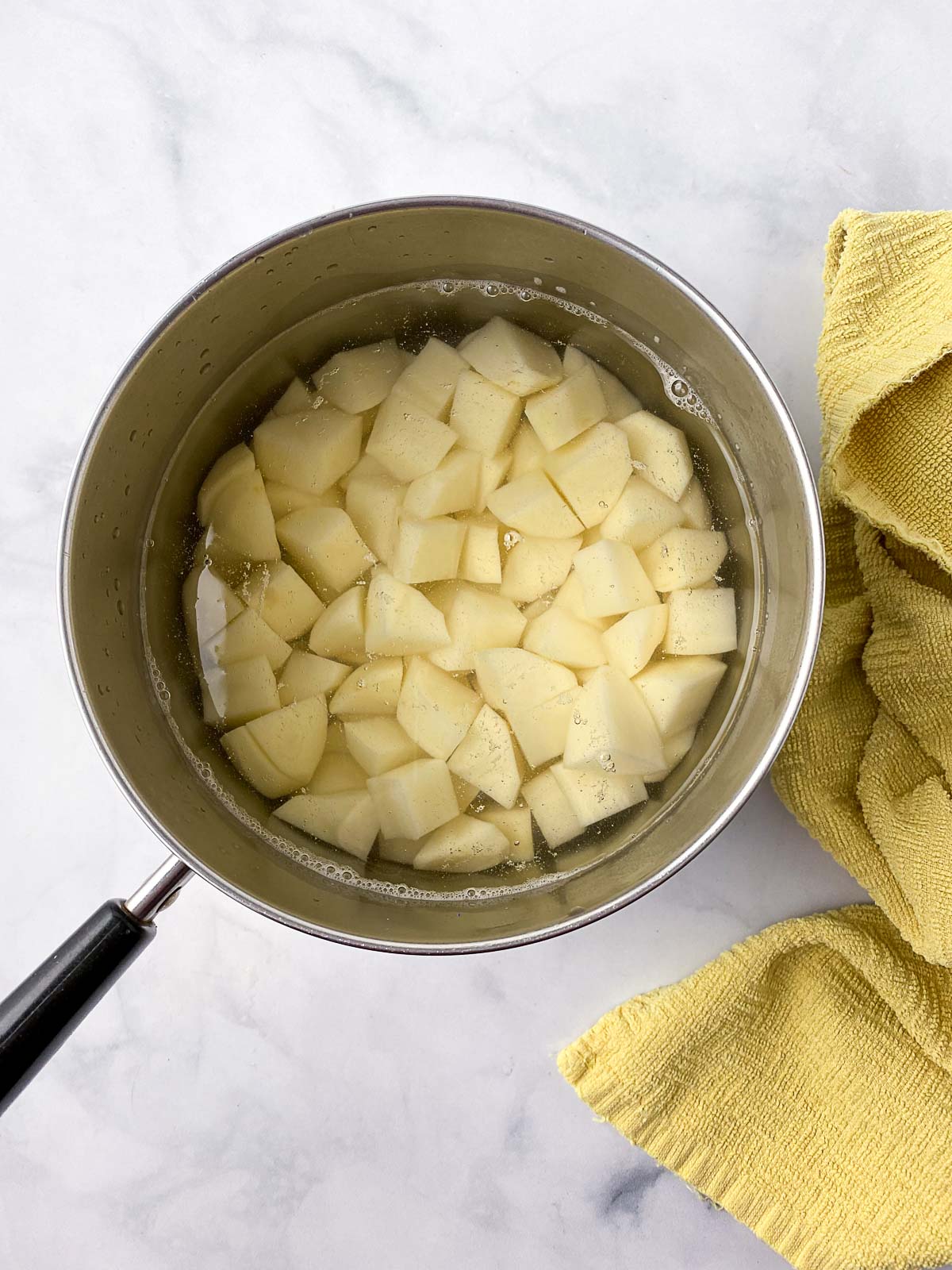 Diced potatoes in a pot of water.
