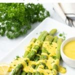Image of asparagus with hollandaise sauce with Pinterest text overlay.