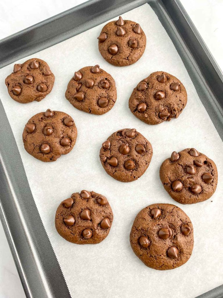 Double chocolate cookies on a parchment lined baking sheet.