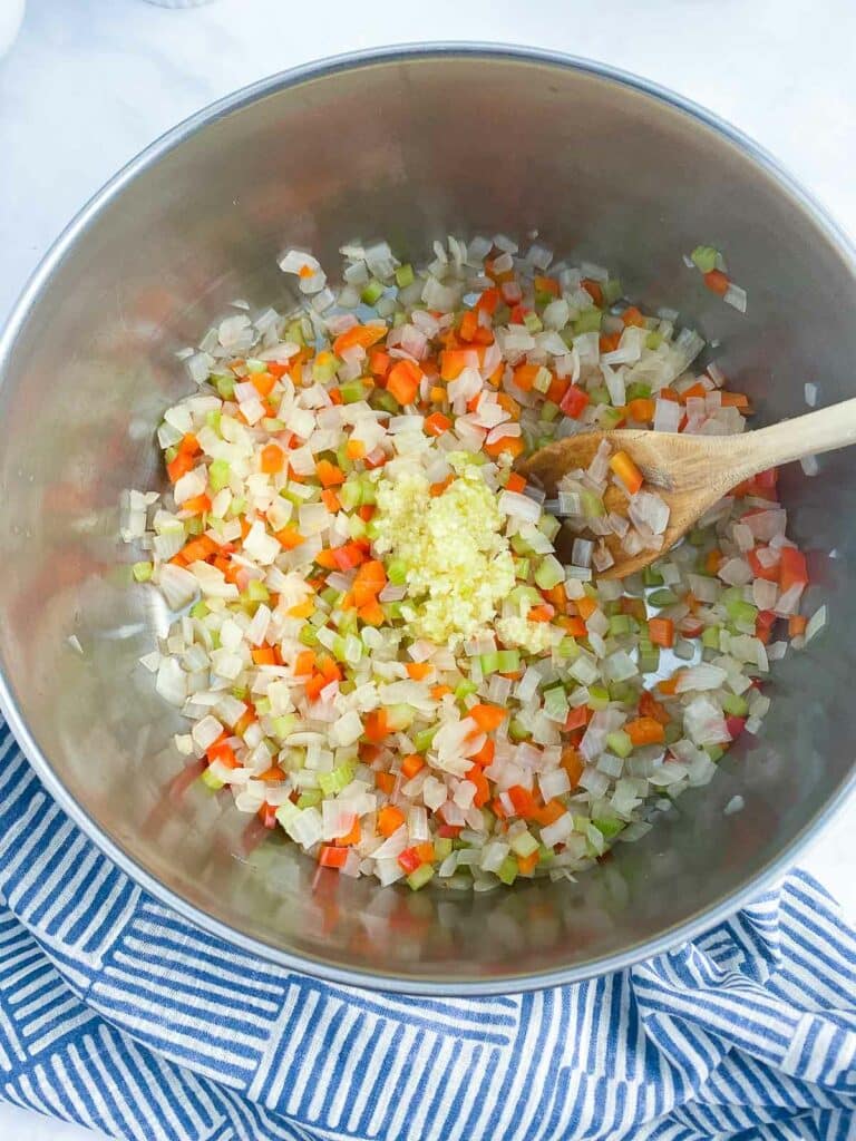 Garlic added to pot of sauteed vegetables.