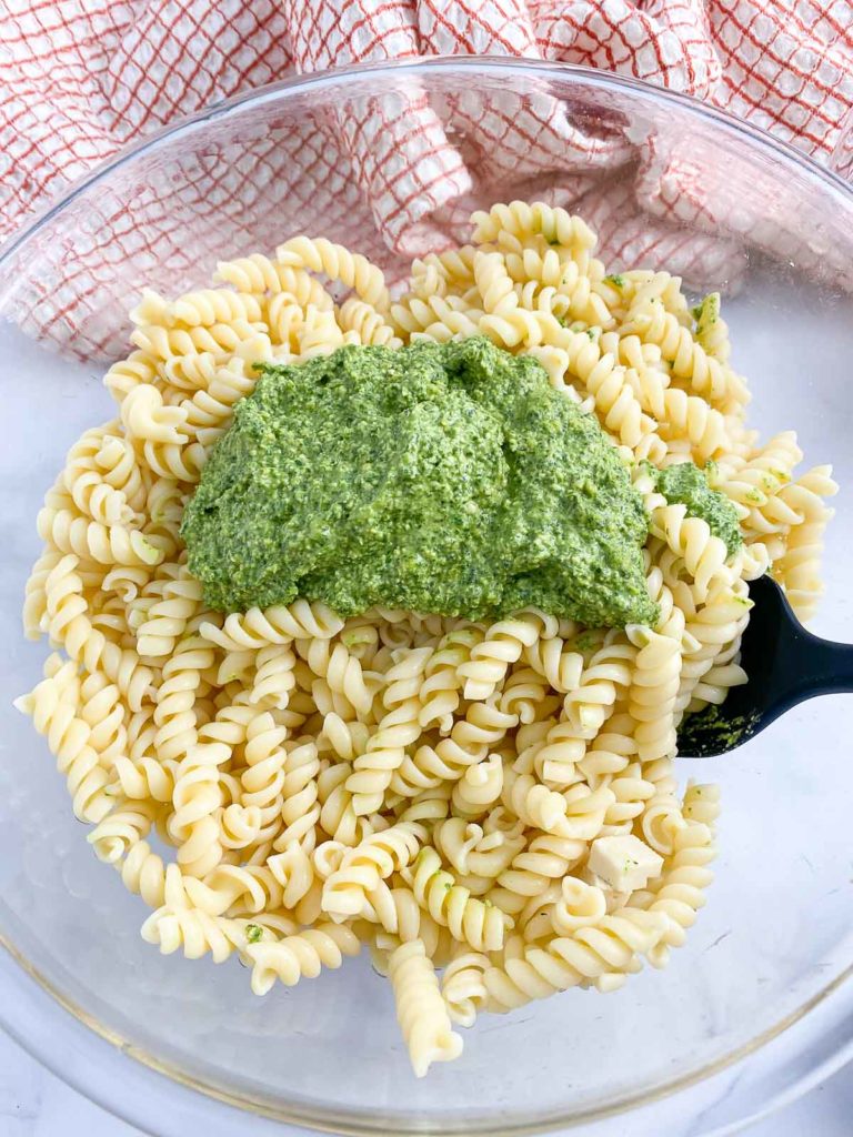Bowl of cooked pasta with pesto added but not mixed in.