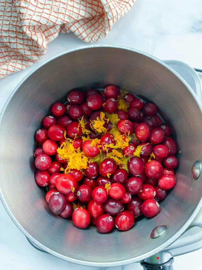 Ingredients for cranberry sauce in sauce pan.