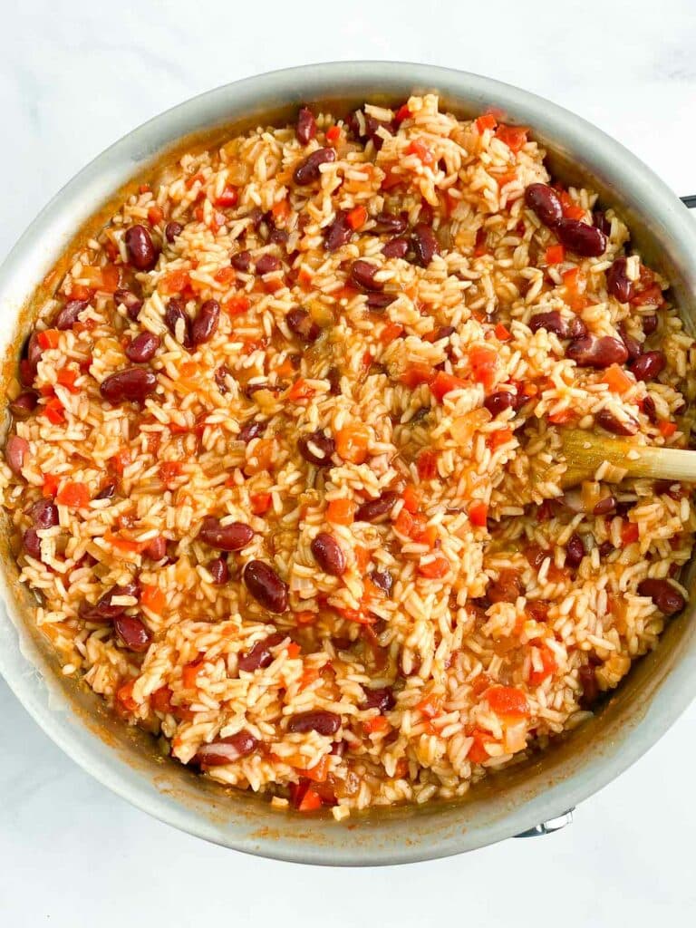Overhead shot of Spanish rice and beans in a stainless steel skillet.