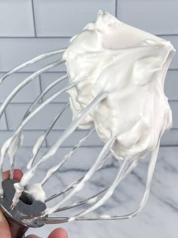 Aquafaba whipped cream on a mixer whisk.