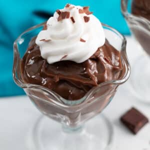 Dessert cup of chocolate pudding with whipped cream and chocolte shavings.