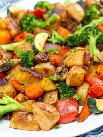 Closeup of roasted vegetables on a white platter.