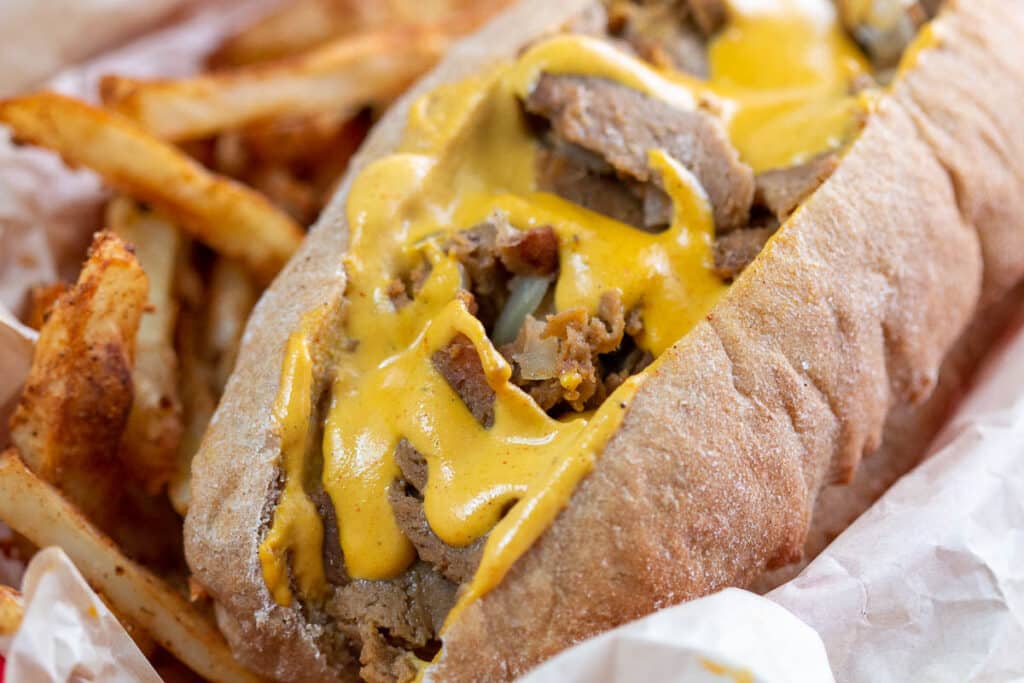 Closeup shot of Philly cheesesteak sandwich and fries.