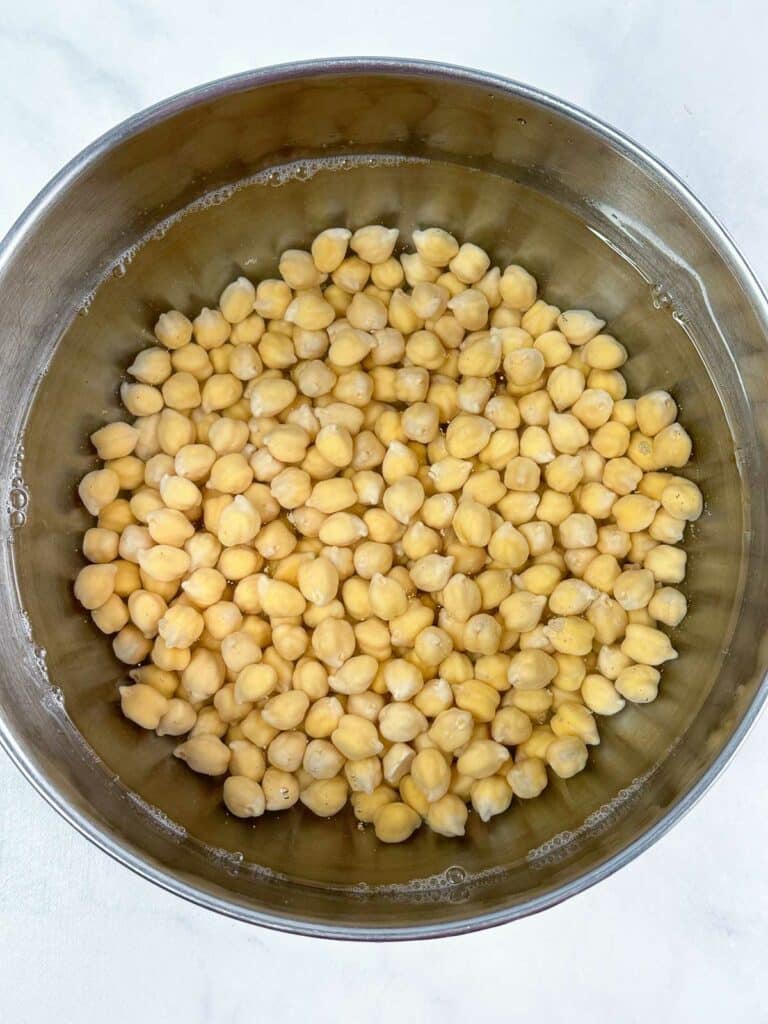 Chickpeas soaking in a bowl of water.