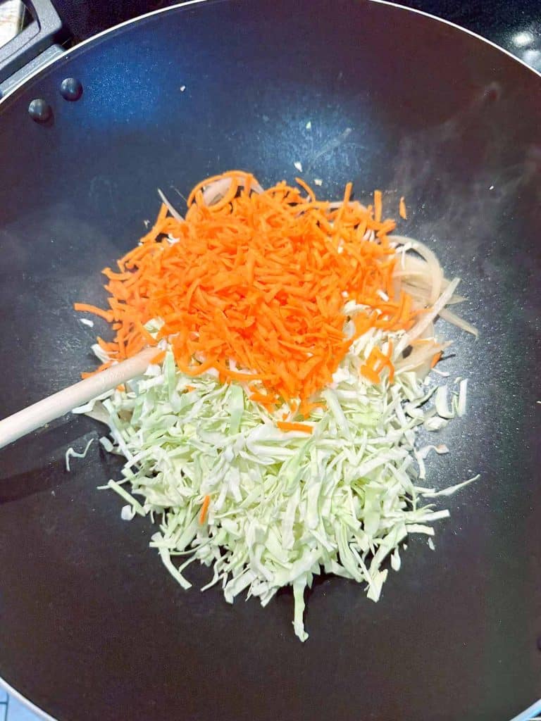Shredded vegetables in a non-stick wok.