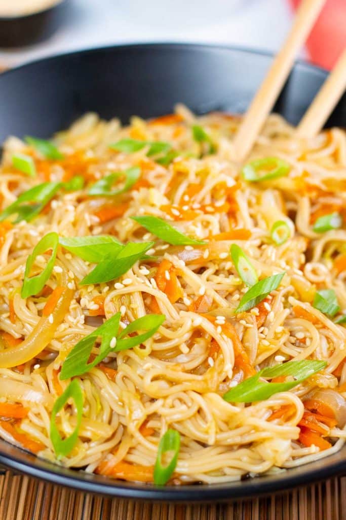 Closeup image of vegan teriyaki noodles in a black bowl.