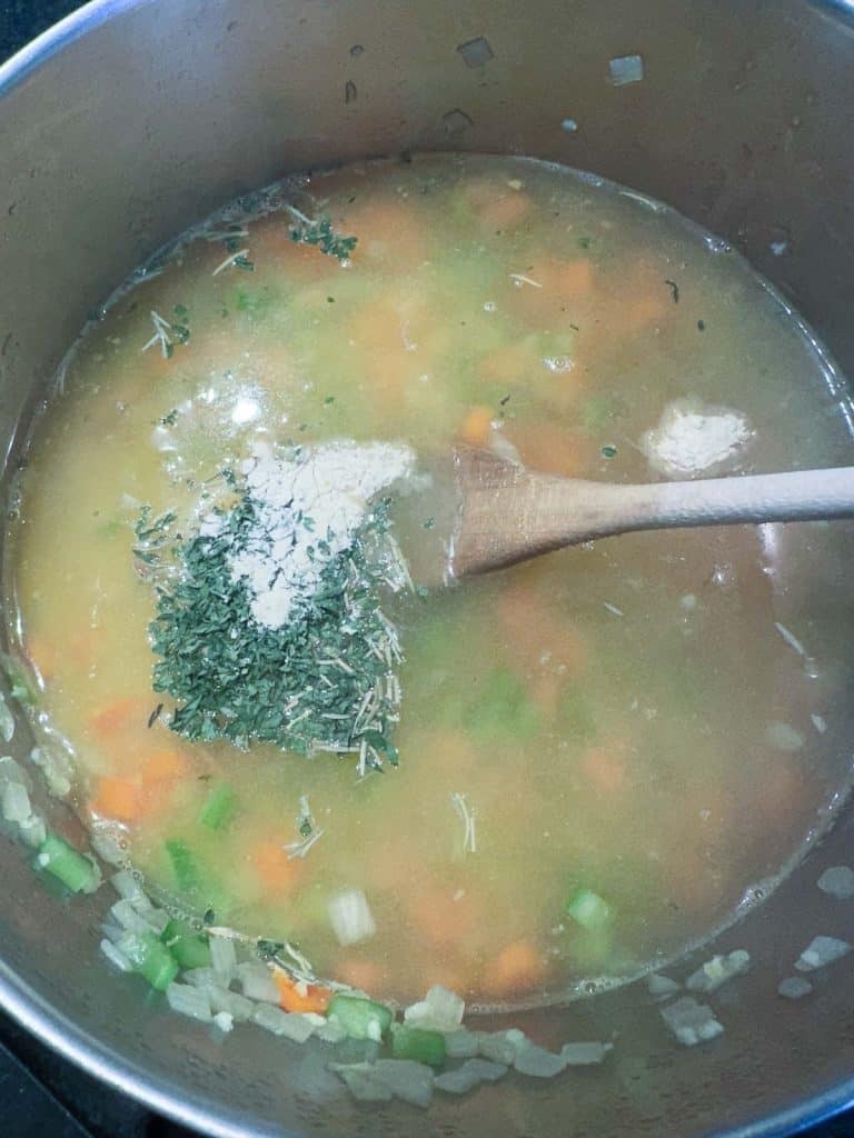 Vegetable broth and seasonings added to the pot of vegetables.