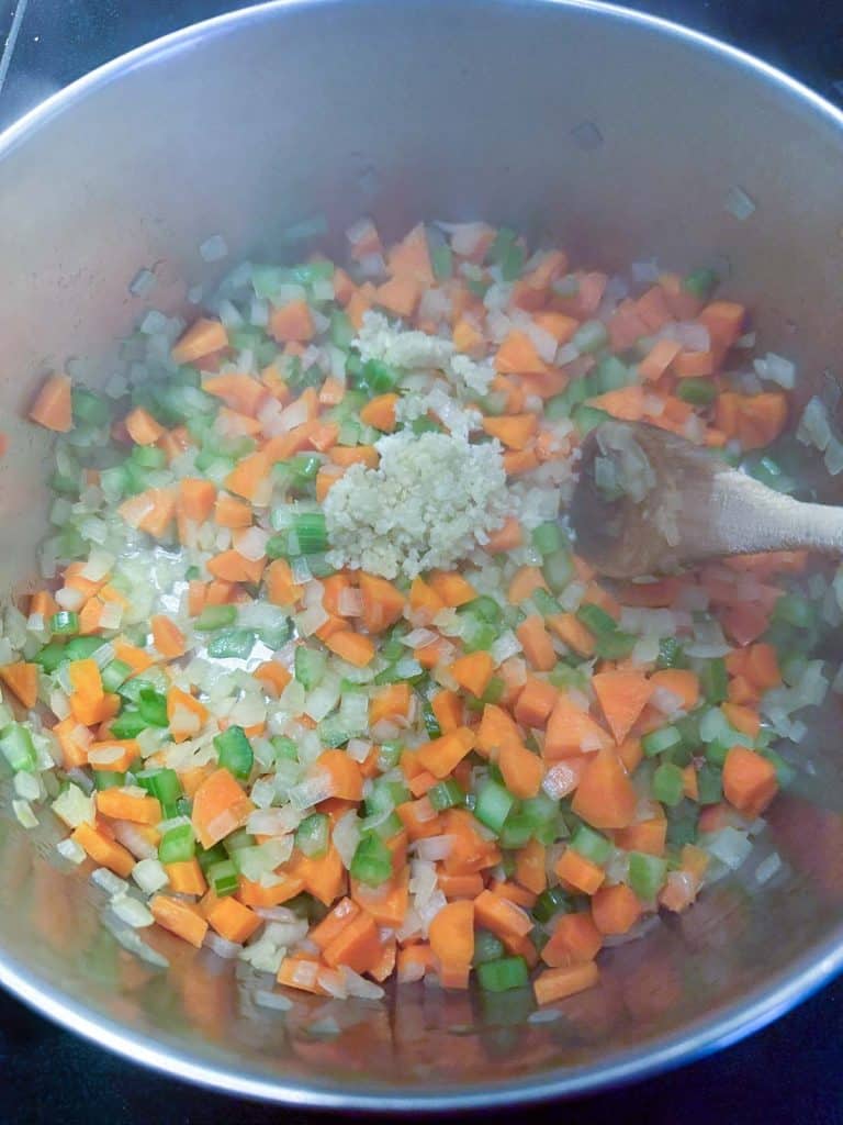 Minced garlic added to the pot of sauteed vegetables.