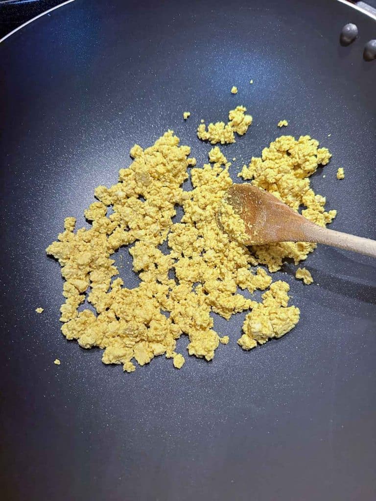 Wok with scrambled tofu for fried rice.